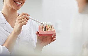 Implant dentist in Canonsburg showing patient a dental restoration