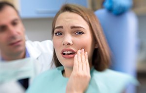 Woman holding jaw in pain