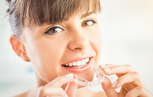 Woman placing Invisalign tray