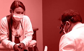 Assistant and dentist treating patient