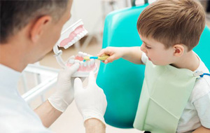 Young boy learning to brush teeth