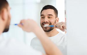 man brushing his teeth 