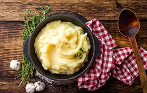 Bowl of mashed potatoes on a wooden table