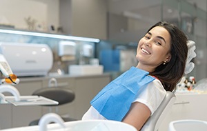 Woman leaning back in dental chair and smiling