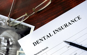 Dental insurance written on yellow post it note