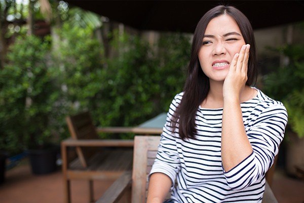 Woman holding her cheek in pain