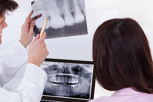 dentist and patient looking at dental xrays