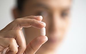 Hand holding an antibiotic pill