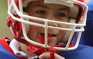 Young boy placing red sportsguard