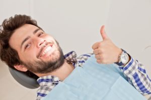 Man with thumb’s up in dentist’s chair