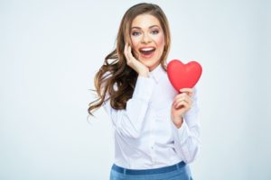 woman holding heart smiling