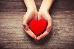 Outstretched hand holding heart shape without gum disease