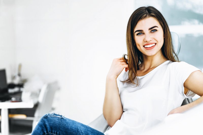 Woman sitting back in dental chair and smiling