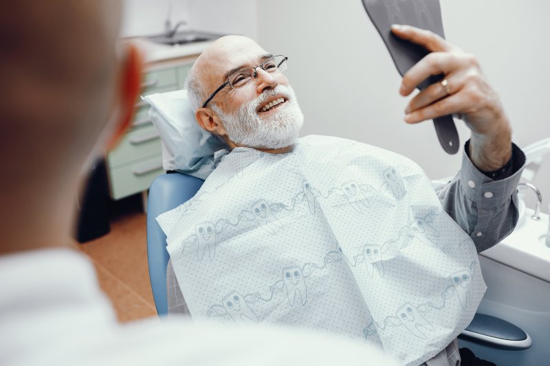 Patient in dental chair smiling with dental implants