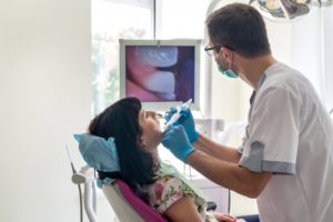 Dentist checking patient's teeth with intraoral camera