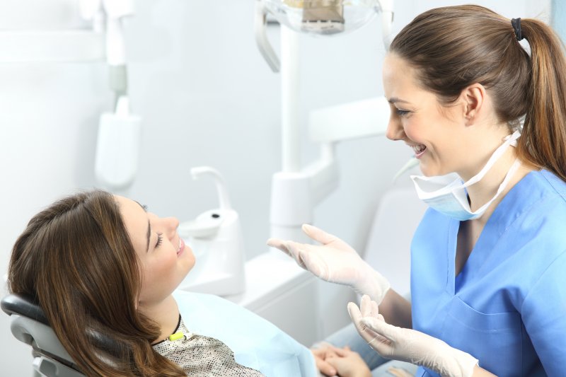 person discussing early detection of oral health problems with dentist