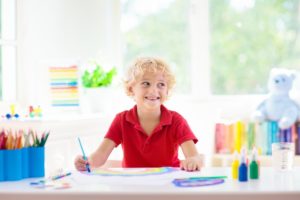 young boy in school coloring a picture