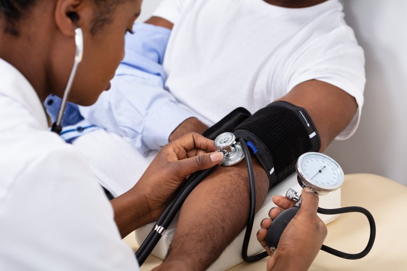 Portrait of a dentist taking a patient’s blood pressure