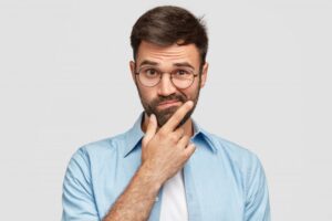 Man wearing glasses with curious expression.